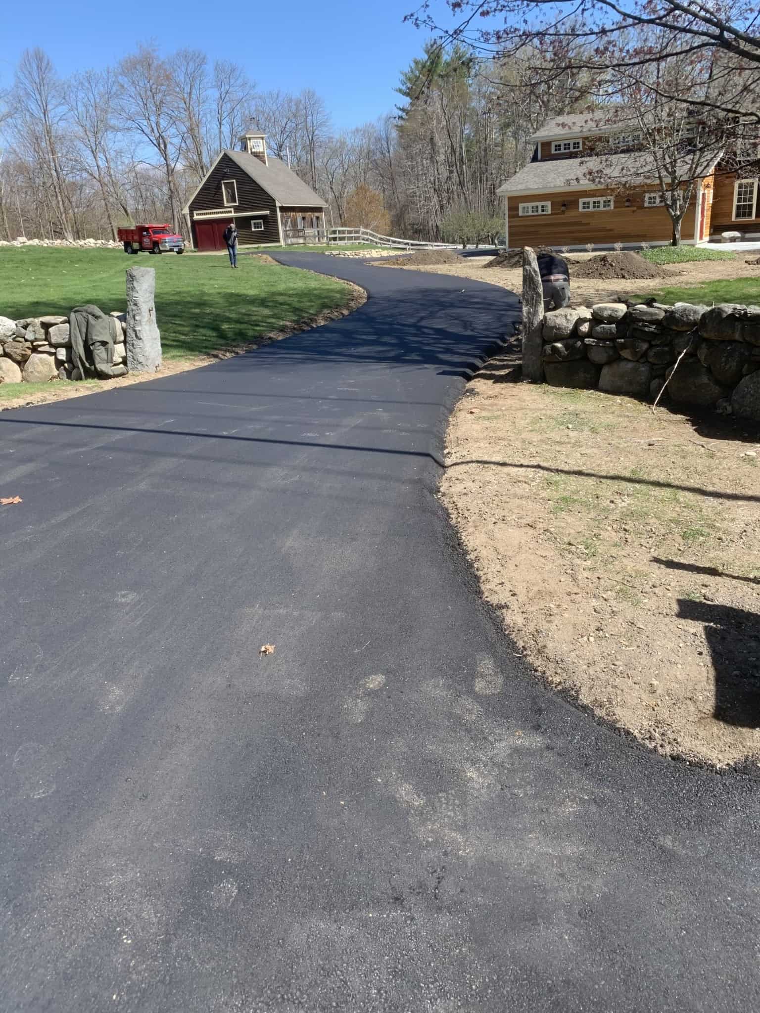 Rural residential driveway paved through stone walls